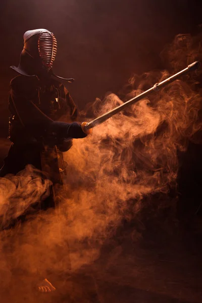Kendo-Kämpfer in Rüstung üben mit Bambusschwert in Rauch — Stockfoto