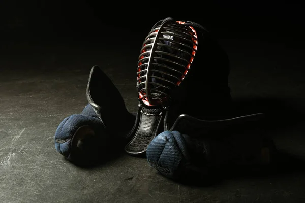 Kendo-Handschuhe und traditioneller Helm auf dunkler Oberfläche — Stockfoto