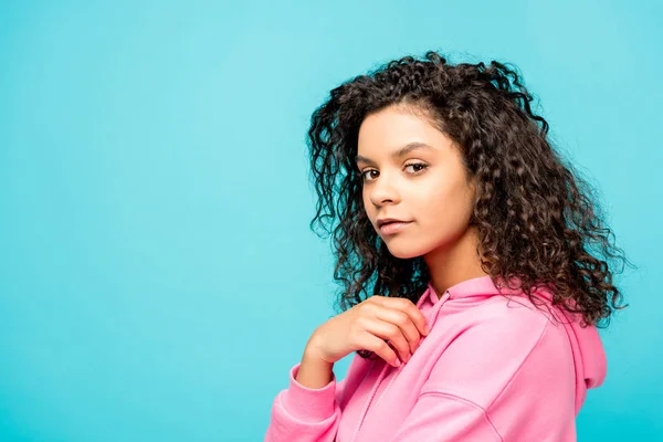 Curly african american young woman looking at camera isolated on blue — Stock Photo