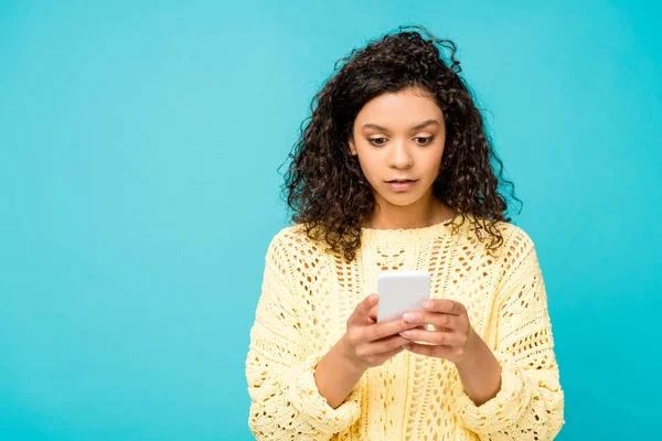 Surprised african american woman looking at smartphone isolated on blue — Stock Photo
