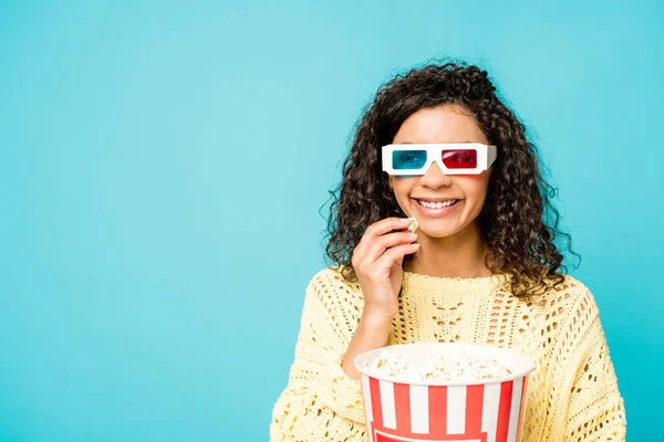 Alegre encaracolado afro-americano mulher em 3d óculos comer pipoca isolado no azul — Fotografia de Stock