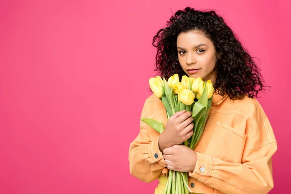 Atraente encaracolado menina americana africana segurando tulipas amarelas isoladas em carmesim — Fotografia de Stock