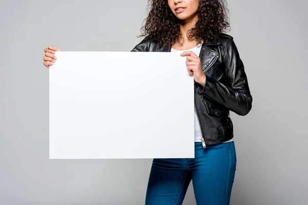 Vista recortada de la joven afroamericana sosteniendo pancarta en blanco aislada en gris - foto de stock