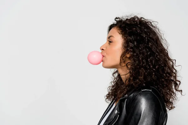 Side view of curly african american girl blowing bubble gum isolated on grey — Stock Photo