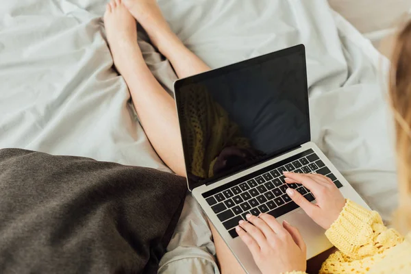 Vista recortada de la niña acostada en la cama y el uso de ordenador portátil con espacio de copia — Stock Photo