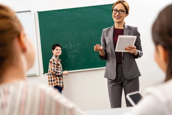 Pupil writing on blackboard with chalk during math lesson — Stock Photo