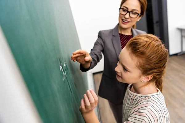 Schüler schreiben im Mathe-Unterricht mit Kreide auf Tafel — Stockfoto