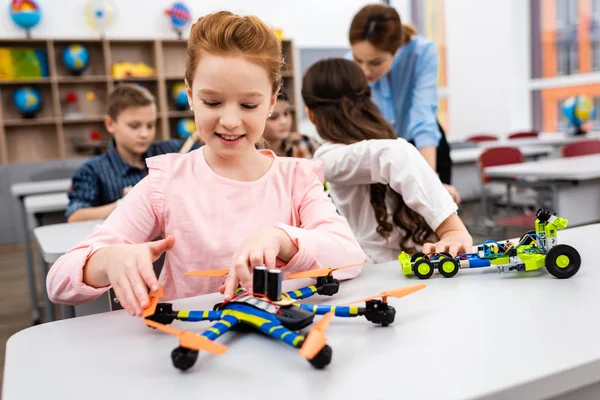 Ученики сидят за столом с учебными игрушками во время урока в классе — стоковое фото