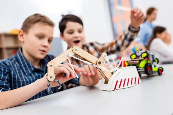 Pupils sitting at desk with educational toys during lesson in classroom — Stock Photo
