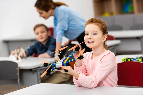 Zenzero studentessa mostrando giocattolo educativo durante la lezione in aula — Foto stock