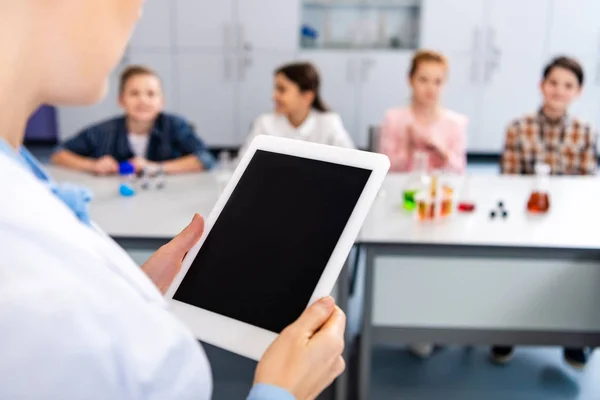 Partial view of chemistry teacher holding digital tablet with blank screen — Stock Photo