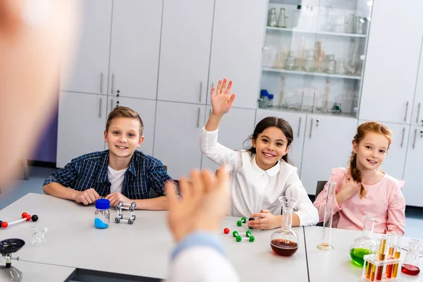 Estudante sorrindo levantando a mão na aula durante a aula de química — Fotografia de Stock