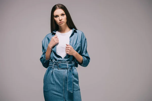 Schöne und brünette Frau im Jeanskleid schaut in die Kamera — Stockfoto