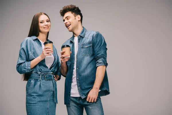 Namorada em vestido de ganga e namorado sorridente em jeans e camisa segurando copos de papel — Fotografia de Stock