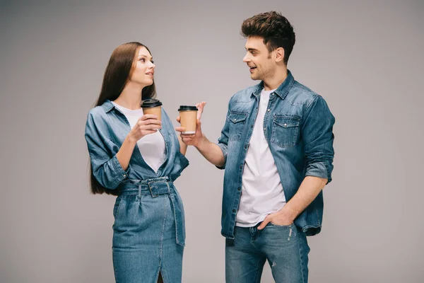 Freundin im Jeanskleid und lächelnder Freund in Jeans und Hemd hält Pappbecher in der Hand und redet — Stockfoto