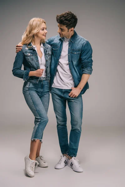 Boyfriend and girlfriend in denim clothes hugging and looking at each other — Stock Photo