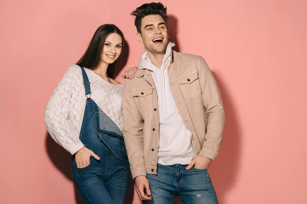 Brünett und schöne Freundin in Jeans-Overalls und schöner Freund lächelnd — Stockfoto