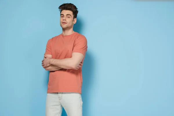 Handsome and brunette man in t-shirt with crossed arms looking at camera — Stock Photo