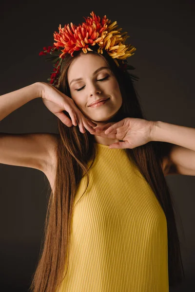 Beautiful and brunette woman with closed eyes in wreath isolated on black — Stock Photo