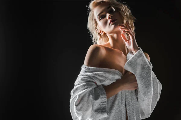 Beautiful sexy girl in white bathrobe posing isolated on black with copy space — Stock Photo