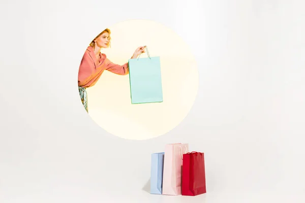 Beautiful stylish young woman holding shopping bag on white with yellow circle and copy space — Stock Photo