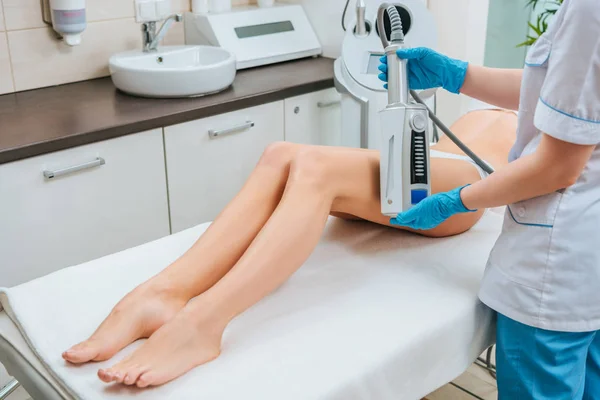 Vista cortada de cosmetologista fazendo terapia de endoesferas para perna — Fotografia de Stock