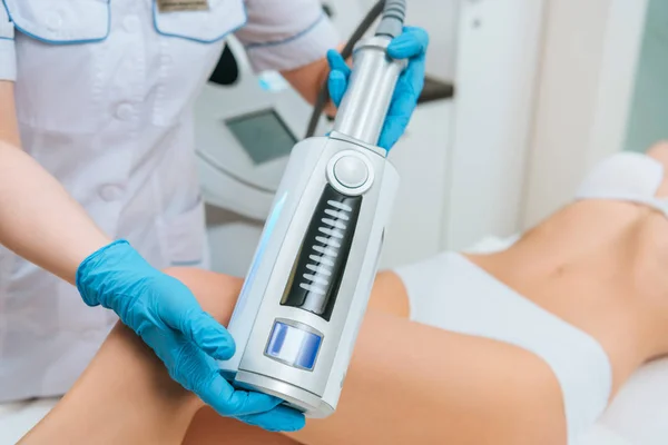 Cropped view of cosmetologist doing therapy for leg — Stock Photo