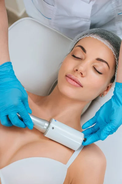 Partial view of cosmetologist in rubber gloves doing  therapy for chest — Stockfoto