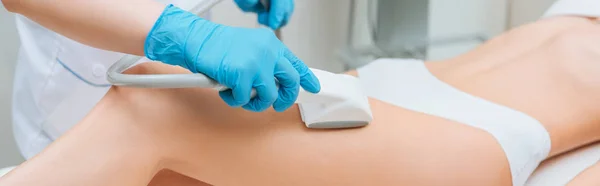 Panoramaaufnahme eines Kosmetikers mit Walze bei einer Beinstarvac-Massage — Stockfoto