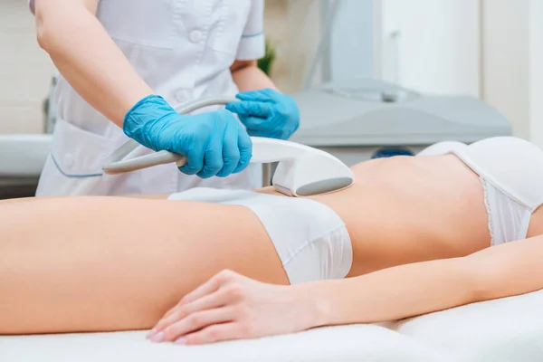 Обрізаний вид косметолога з роликом робить масаж живота зіркою — стокове фото