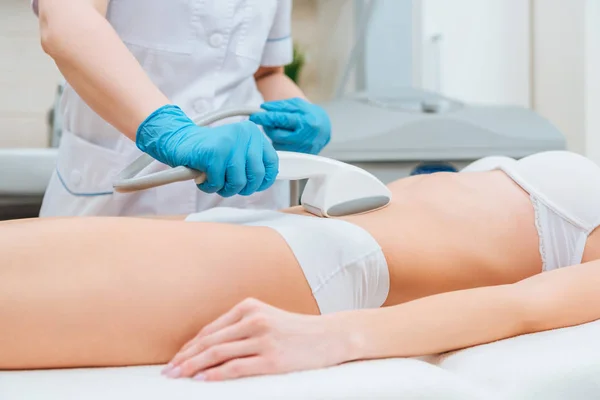 Ausgeschnittene Ansicht des Kosmetikers mit Walze bei der Bauchmassage — Stockfoto