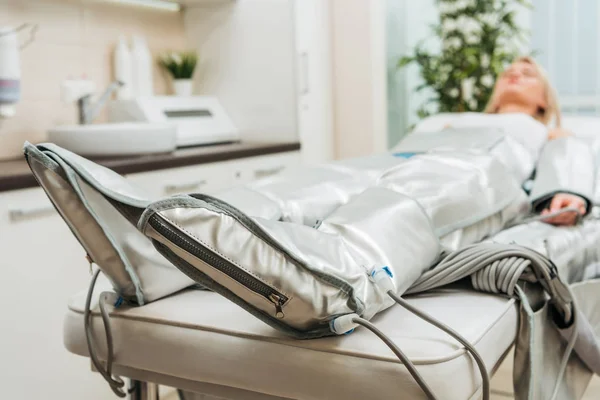 Selective focus on woman lying on beauty couch during pressotherapy session — Stock Photo