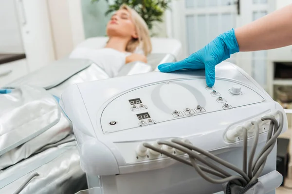 Vista cortada do cosmetologist que configura a máquina para a pressoterapia — Fotografia de Stock