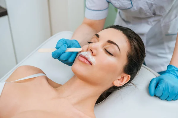 Vista parcial do cosmetologista em luvas de borracha fazendo depilação alcalina — Fotografia de Stock