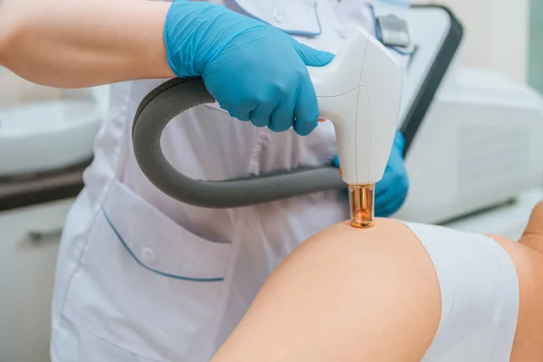 Cropped view of cosmetologist in rubber gloves doing laser treatment — Stock Photo