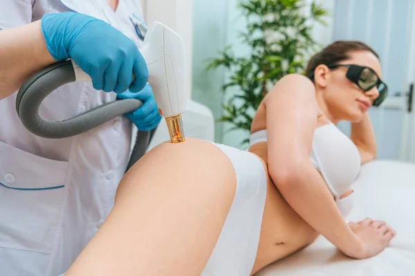 Cropped view of cosmetologist in rubber gloves doing laser treatment — Stock Photo