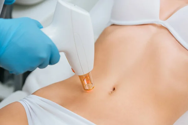 Cropped view of cosmetologist in rubber gloves doing laser treatment — Stock Photo