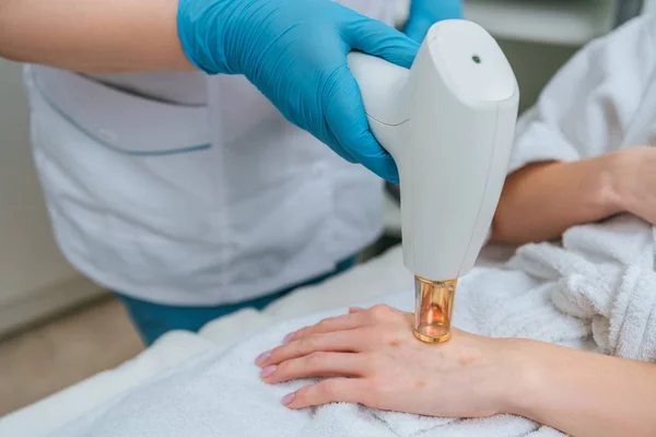 Cropped view of cosmetologist in rubber gloves doing laser treatment — Stock Photo