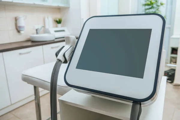 Laser machine with blank screen near beauty couch in clinic — Stock Photo