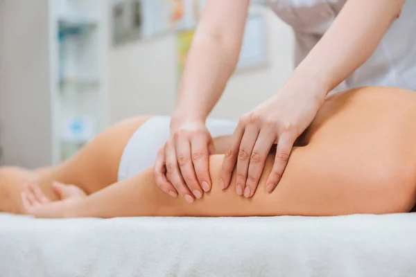 Cropped view of masseur doing arm massage to girl on massage table — Stock Photo