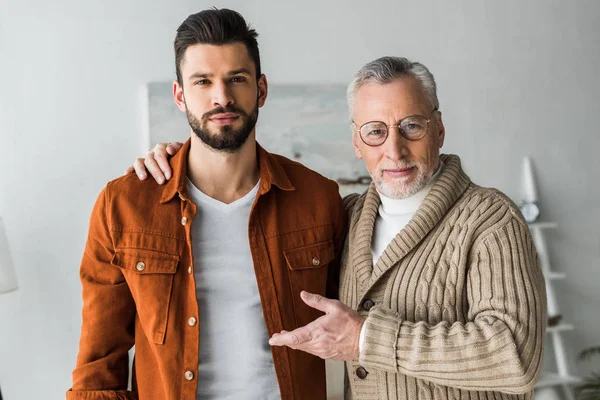 Père aîné geste près beau fils barbu — Photo de stock