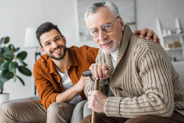 Selektive Fokussierung des fröhlichen älteren Mannes und seines hübschen Sohnes auf die Kamera — Stockfoto