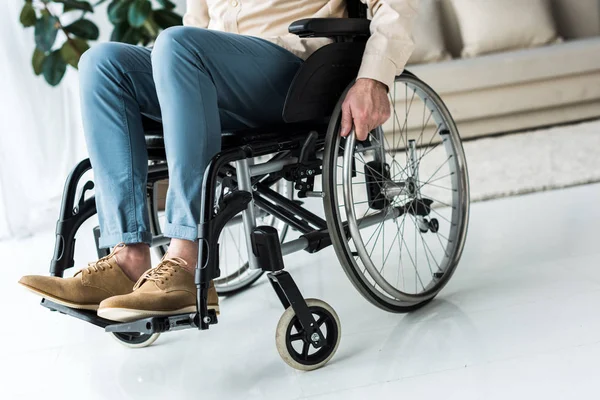 Cropped view of disabled senior man sitting in wheelchair at home — Stock Photo