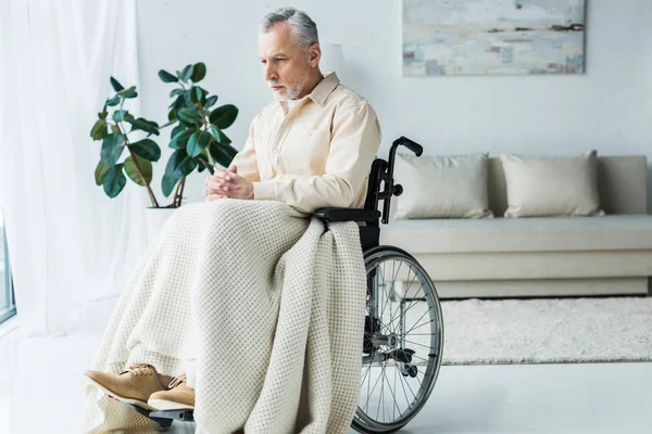 Sad disabled retired man sitting in wheelchair with clenched hands — Stock Photo