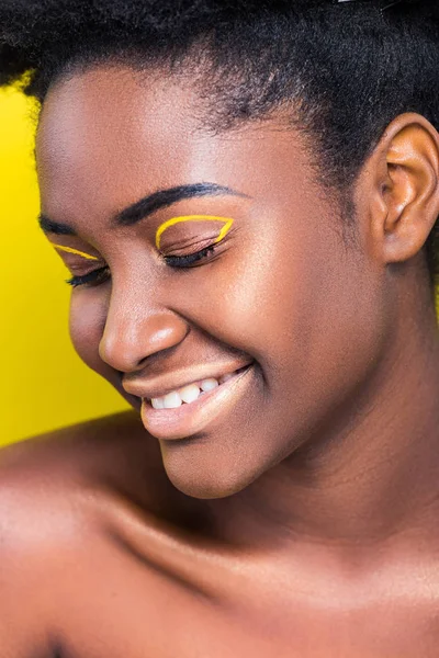 Smiling african american girl with closed eyes isolated on yellow — Stock Photo