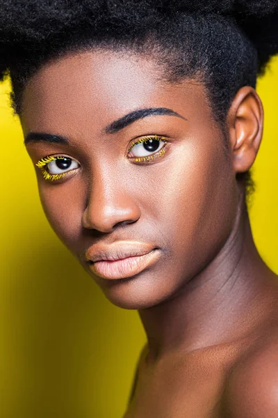 Pretty african american girl looking at camera on yellow — Stock Photo