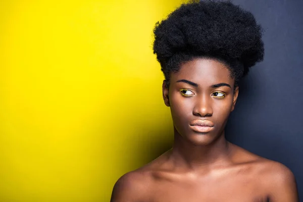 Pensive african american woman looking away on black and yellow — Stock Photo