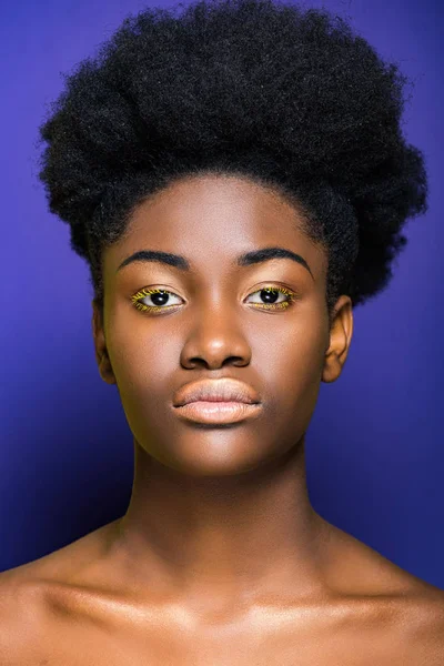 Hermosa mujer joven afroamericana con pestañas amarillas en púrpura - foto de stock