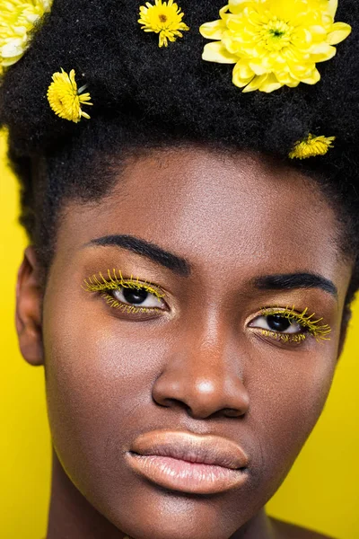 Portrait of african american woman with flowers in hair isolated on yellow — Stock Photo