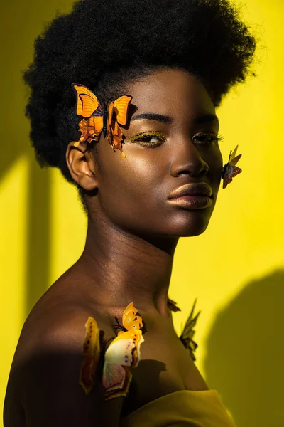 Attrayant afro-américain jeune femme avec des papillons sur jaune — Photo de stock